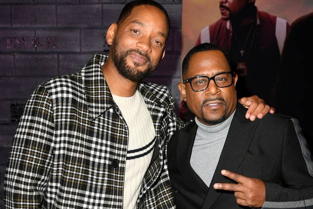 Will Smith and Martin Lawrence pose together at a red carpet event. Will Smith wears a checkered coat; Martin Lawrence wears a black suit with a turtleneck