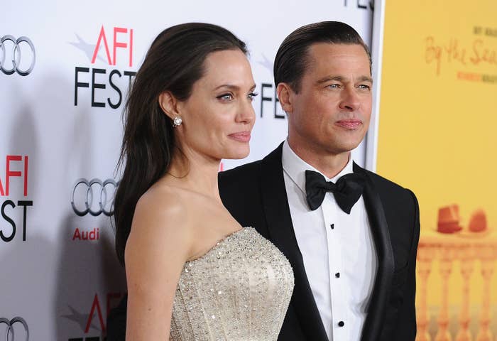 Angelina Jolie and Brad Pitt on the red carpet at AFI Fest. Jolie wears a beaded strapless gown, while Pitt is in a tuxedo with a bow tie