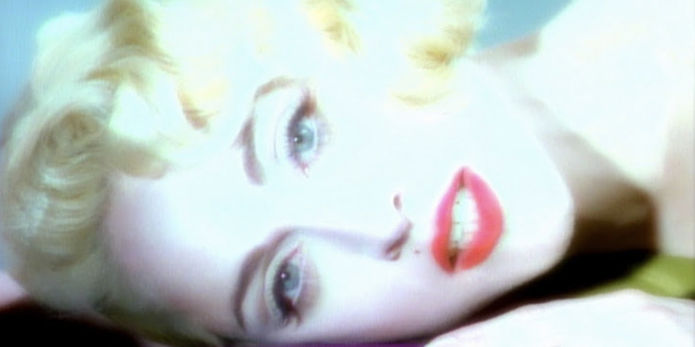Madonna close-up with blonde hair and red lipstick, lying down with a soft expression