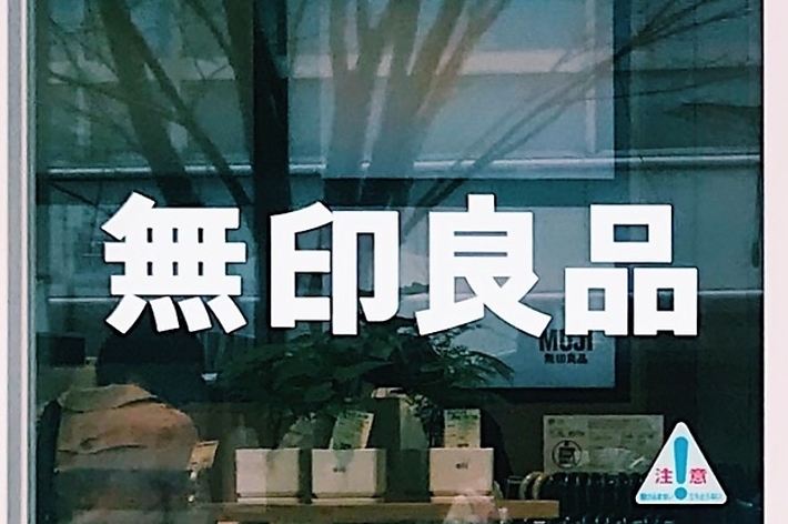 無印良品の店舗の入り口。ガラスに反射している木の影。