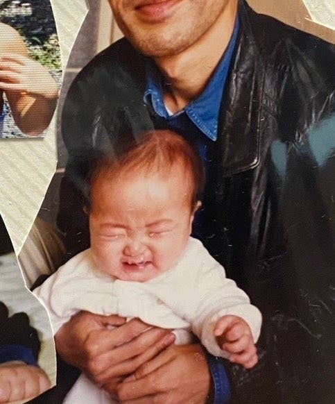 男性が赤ちゃんを抱いている写真です。男性は革ジャンを着ています。