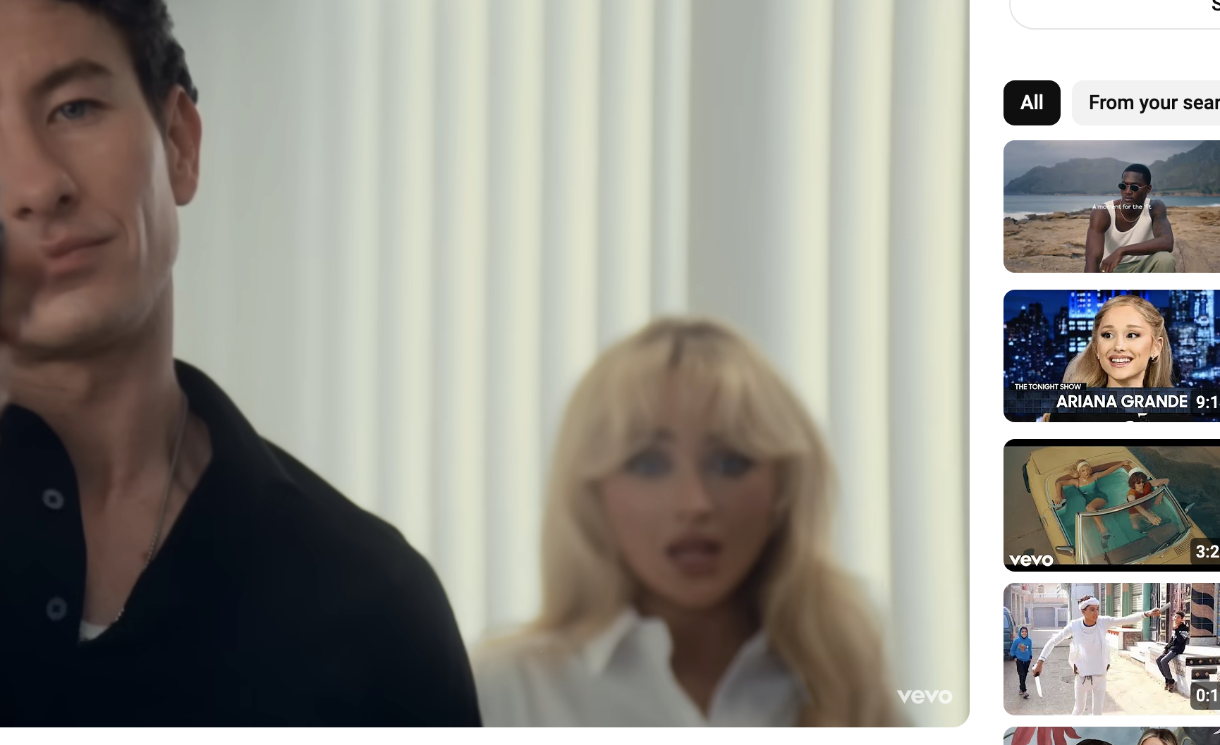 Barry Keoghan pointing a gun while Sabrina Carpenter stands shocked in background, from the &quot;Please Please Please&quot; official video on YouTube