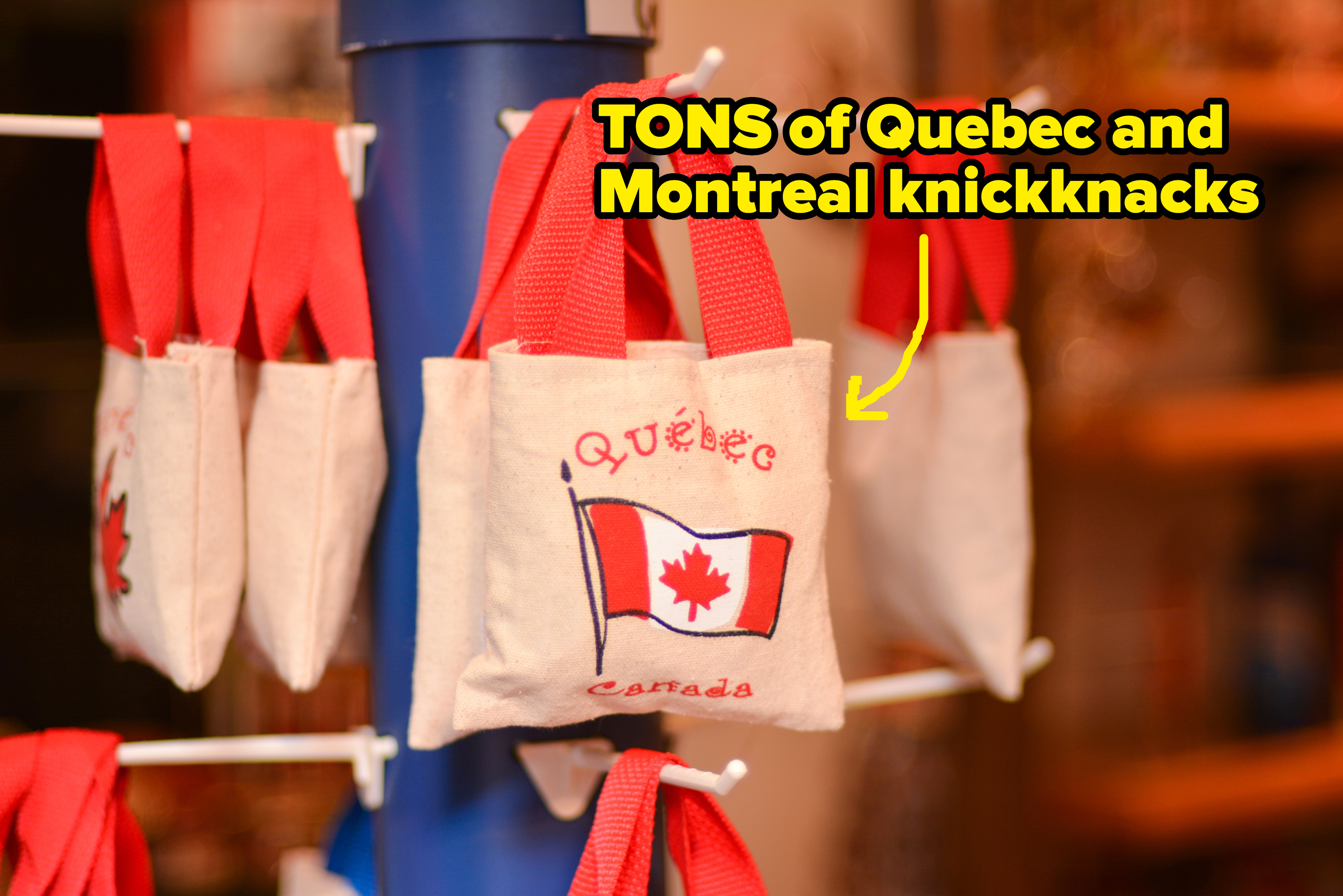 Mini tote bags with "Québec Canada" and a maple leaf flag design hanging on display