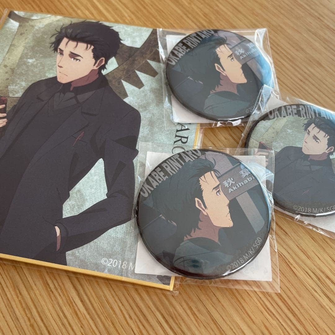 アニメキャラクター牧瀬紅莉栖のグッズセット。イラスト付きカードと缶バッジが含まれています。