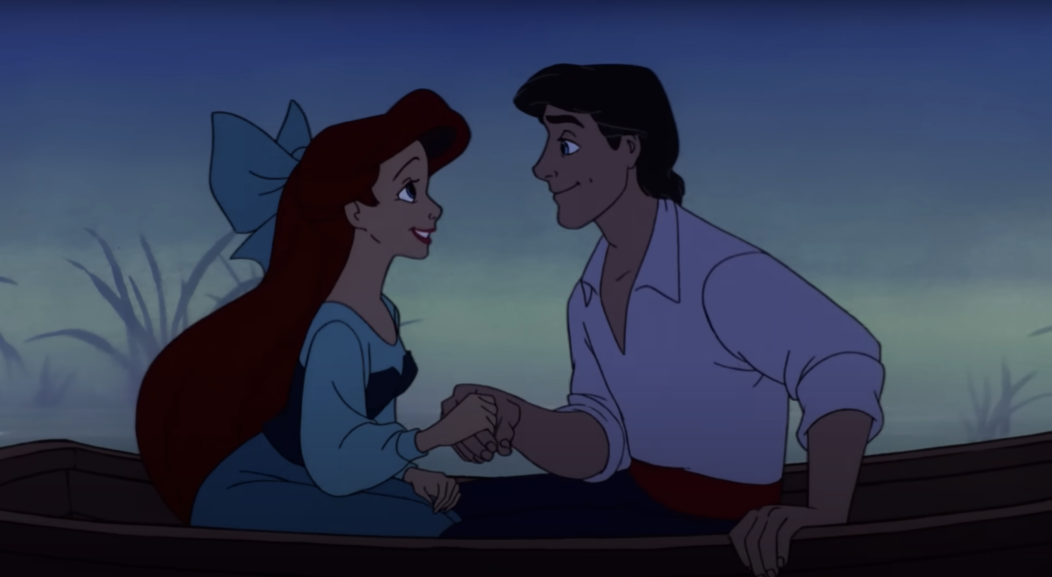 Ariel and Prince Eric from The Little Mermaid hold hands and smile at each other while sitting in a boat on water