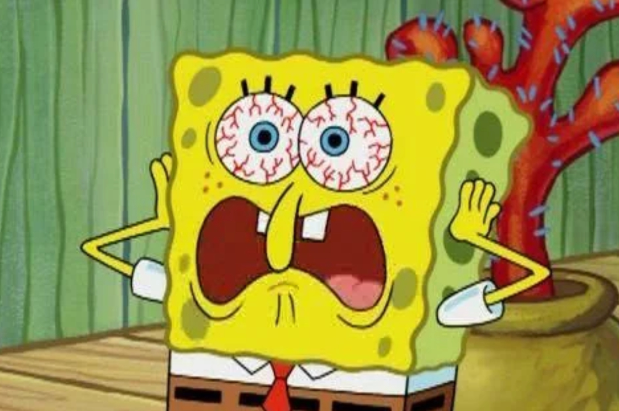 SpongeBob SquarePants with wide eyes, red veins, hands on his face, looking shocked and scared in front of a coral background