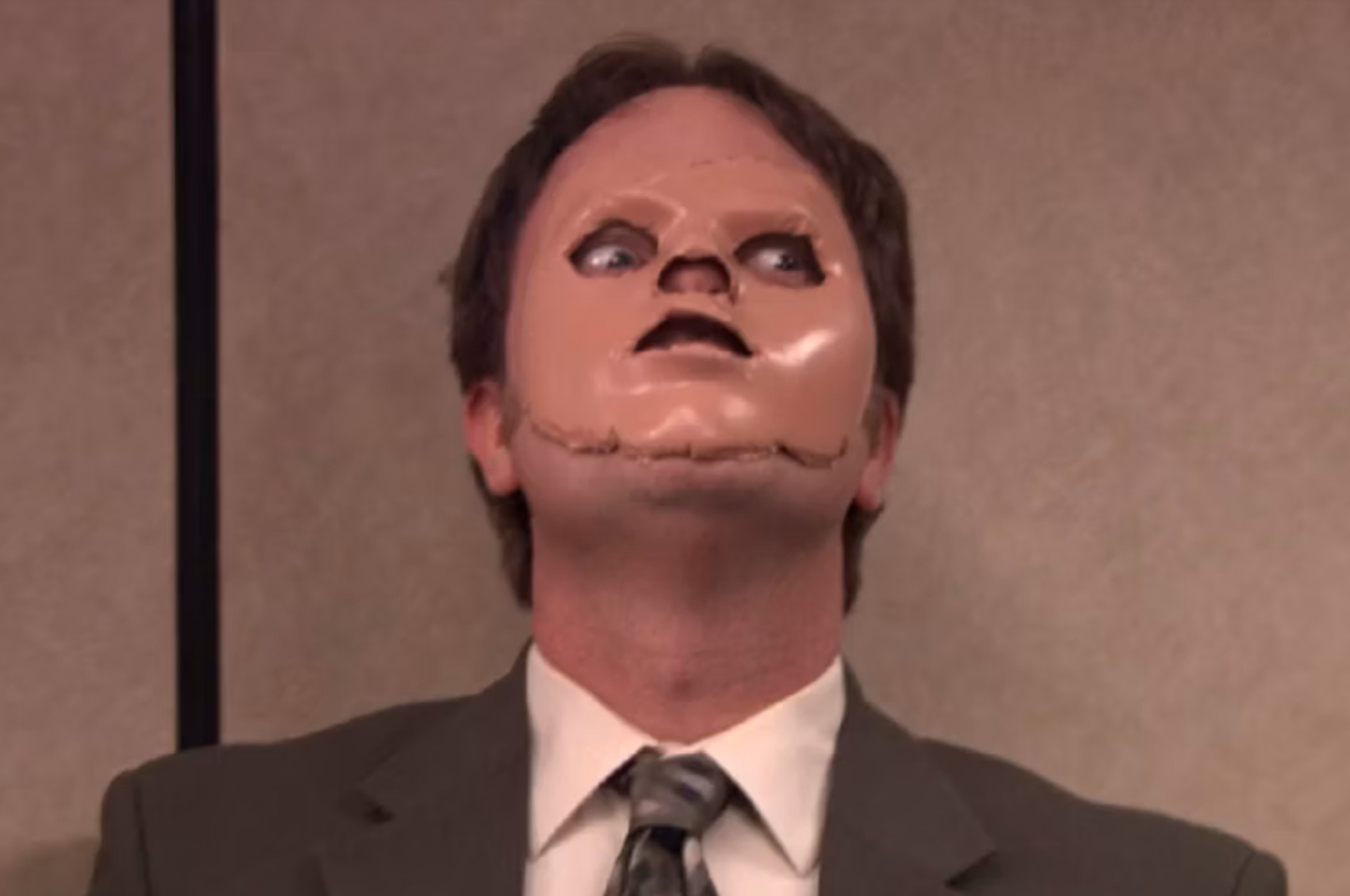 Dwight Schrute wearing a partial CPR training mask over his face while in a suit, from a scene in &quot;The Office.&quot;