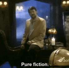 Jonathan Frakes, in a casual blazer, sits on a desk in a dimly lit room with candles and a globe, saying "Pure fiction."