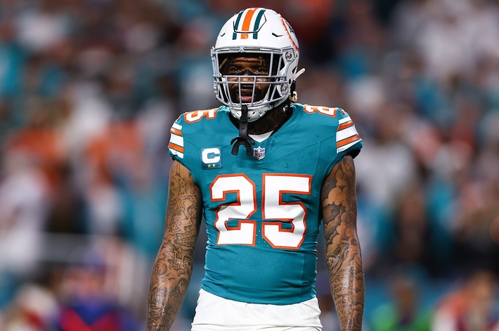 Xavien Howard, wearing a football uniform and helmet, stands on a field during a game
