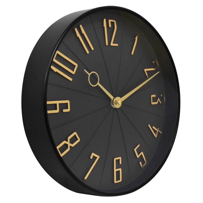 The wall clock featuring gold numbers and hands