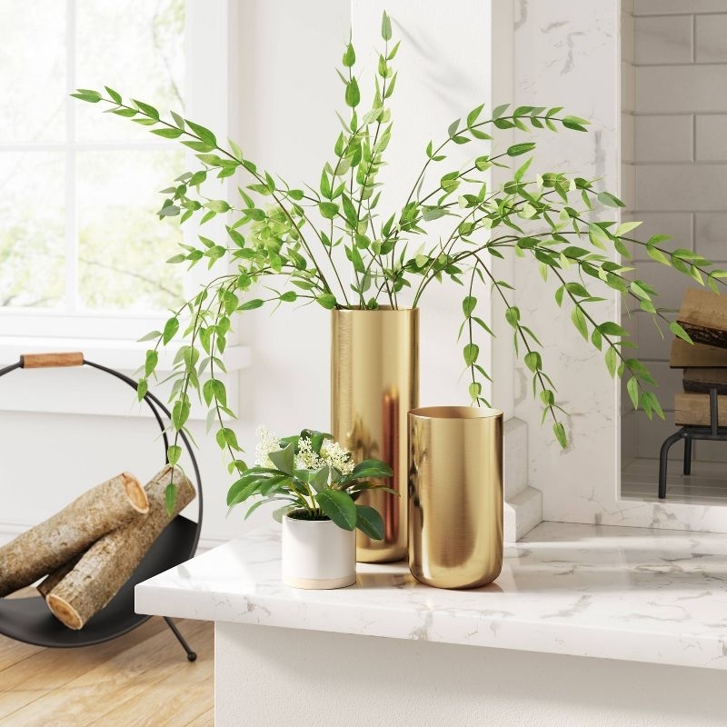 gold vases holding plants on a kitchen counter