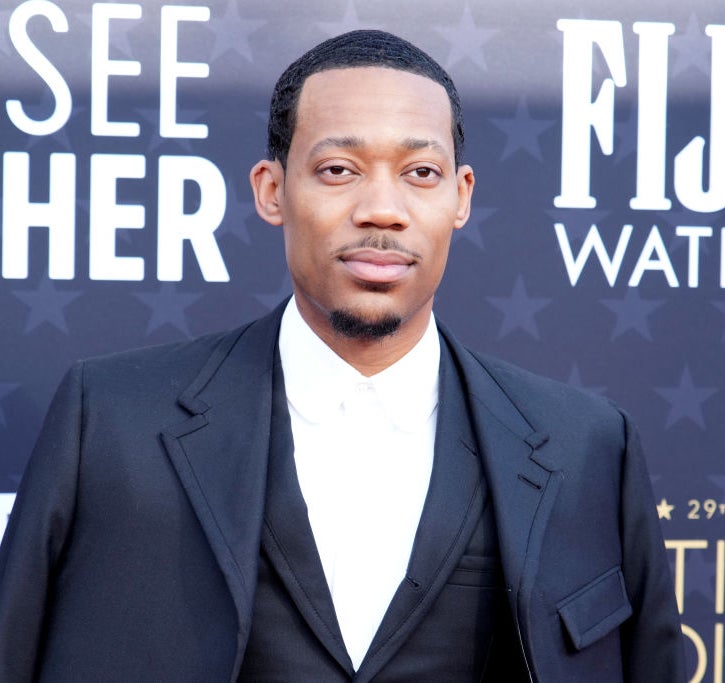 Tyler James Williams at the Critics Choice Awards, wearing a black suit with a black tie and white shirt