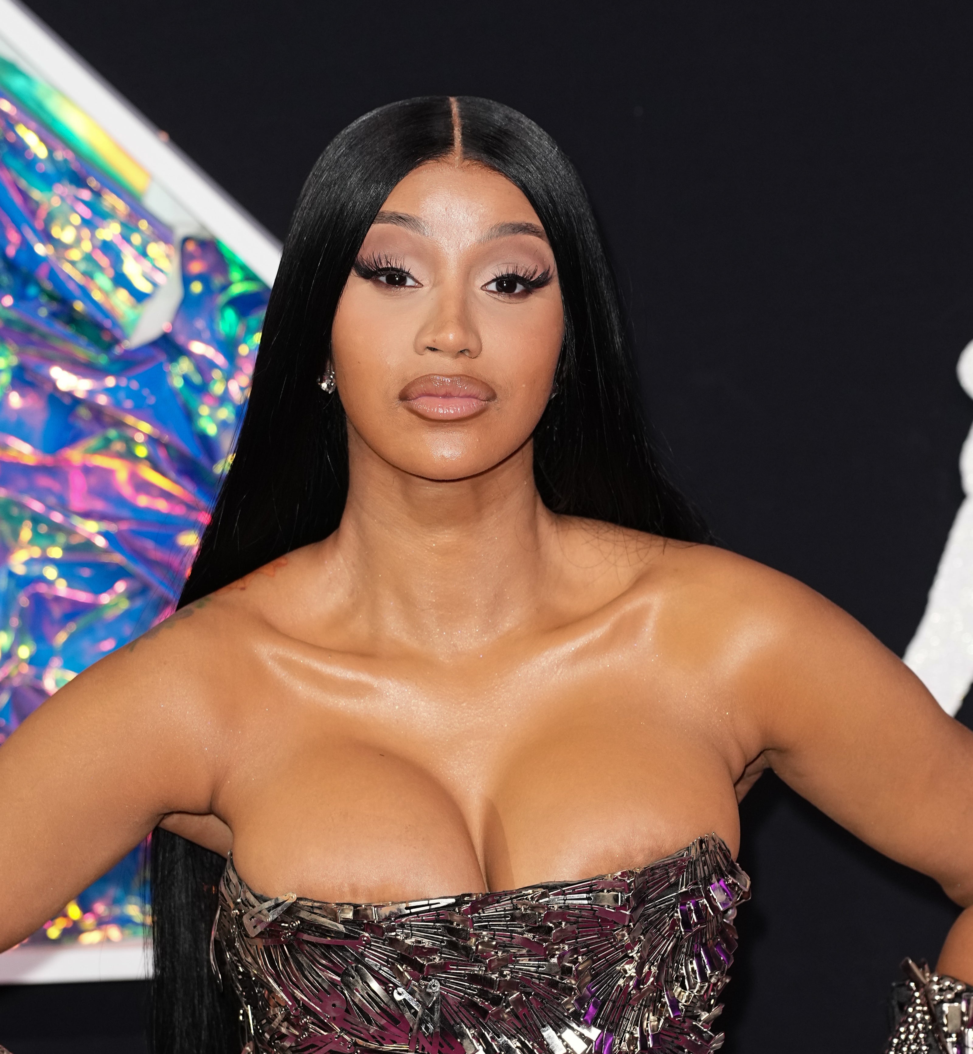 Cardi B poses on the red carpet wearing a strapless, metallic-patterned dress