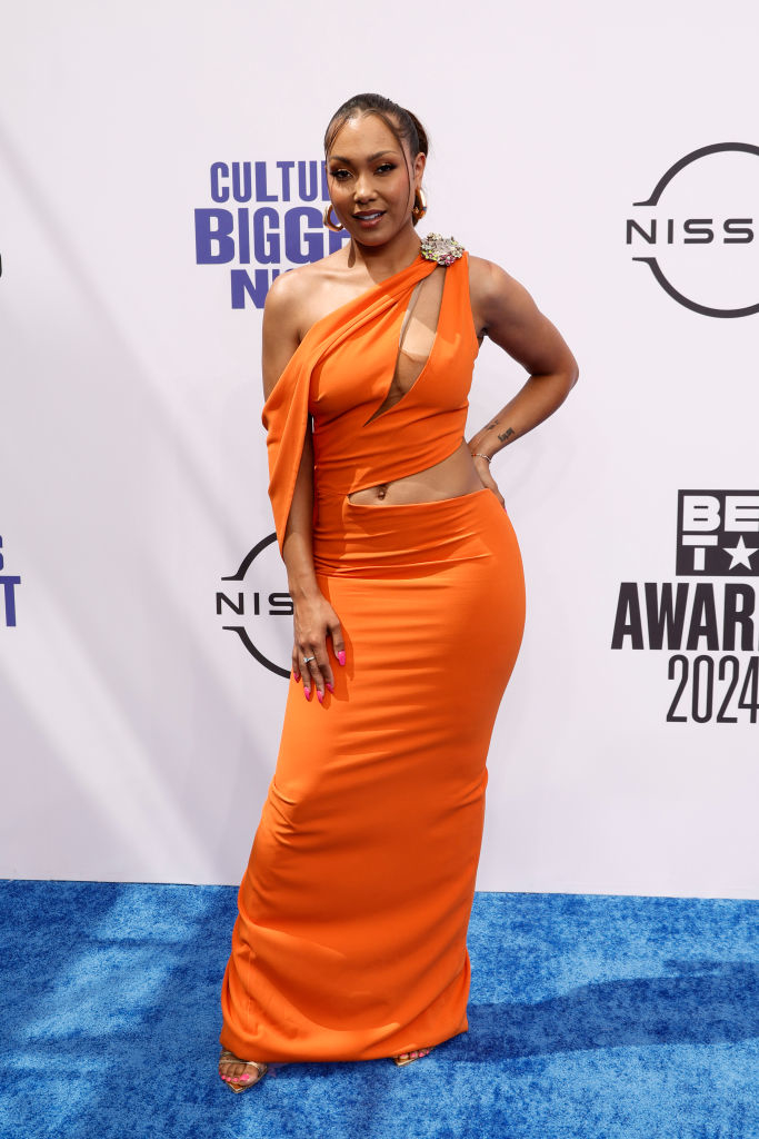 Parker McKenna Posey poses on the red carpet at the BET Awards 2024, wearing an elegant one-shoulder, cut-out gown