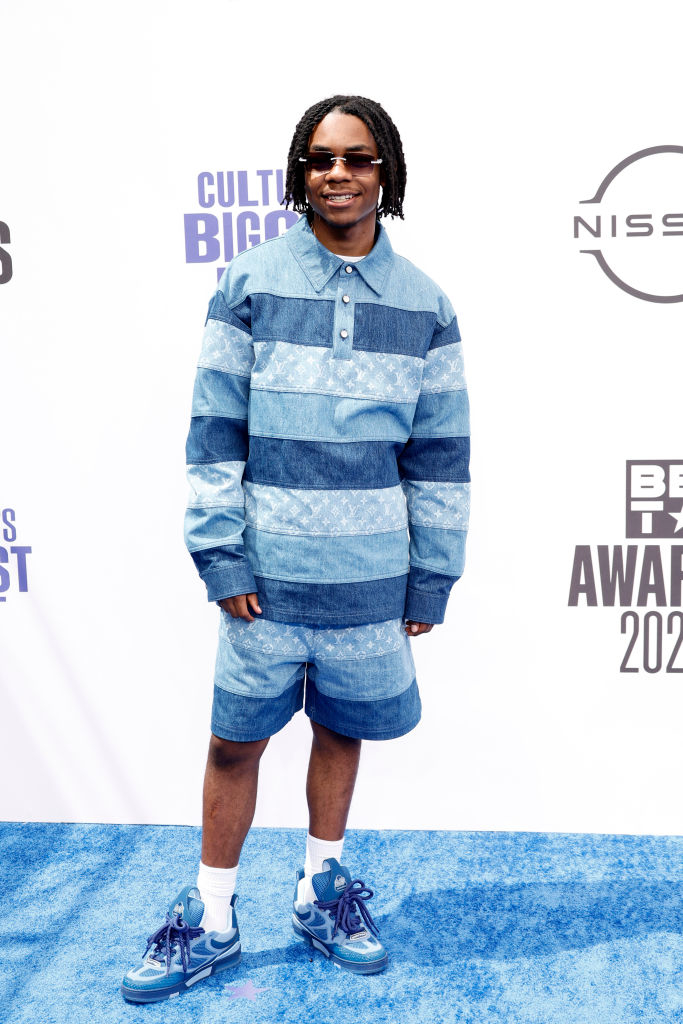 310babii on a red carpet wearing a blue striped denim shirt with matching shorts, blue sneakers, and sunglasses at the BET Awards 2022