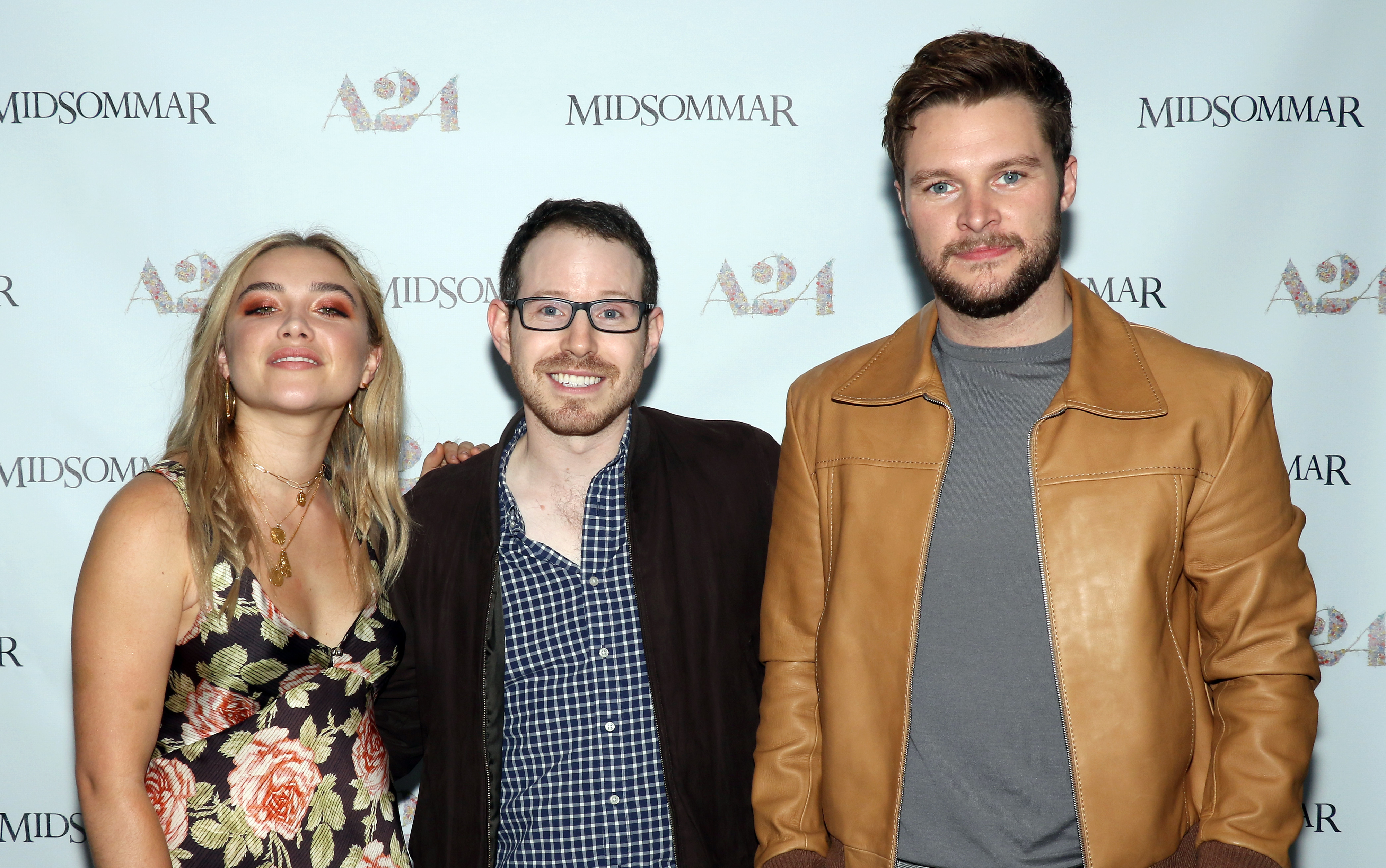 Florence Pugh in a floral dress, Ari Aster in a checkered shirt, and Jack Reynor in a tan jacket at a &quot;Midsommar&quot; event