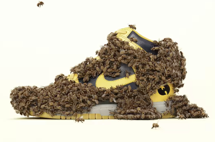 A sneaker covered in bees on a plain background