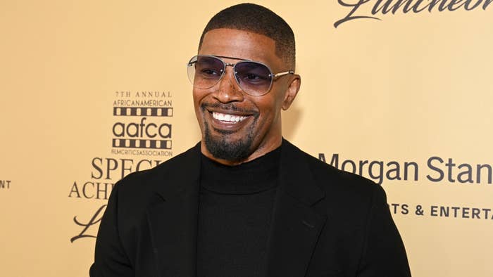 Jamie Foxx at the 7th Annual African American Film Critics Association Special Achievement Luncheon, dressed in a black turtleneck and blazer with sunglasses