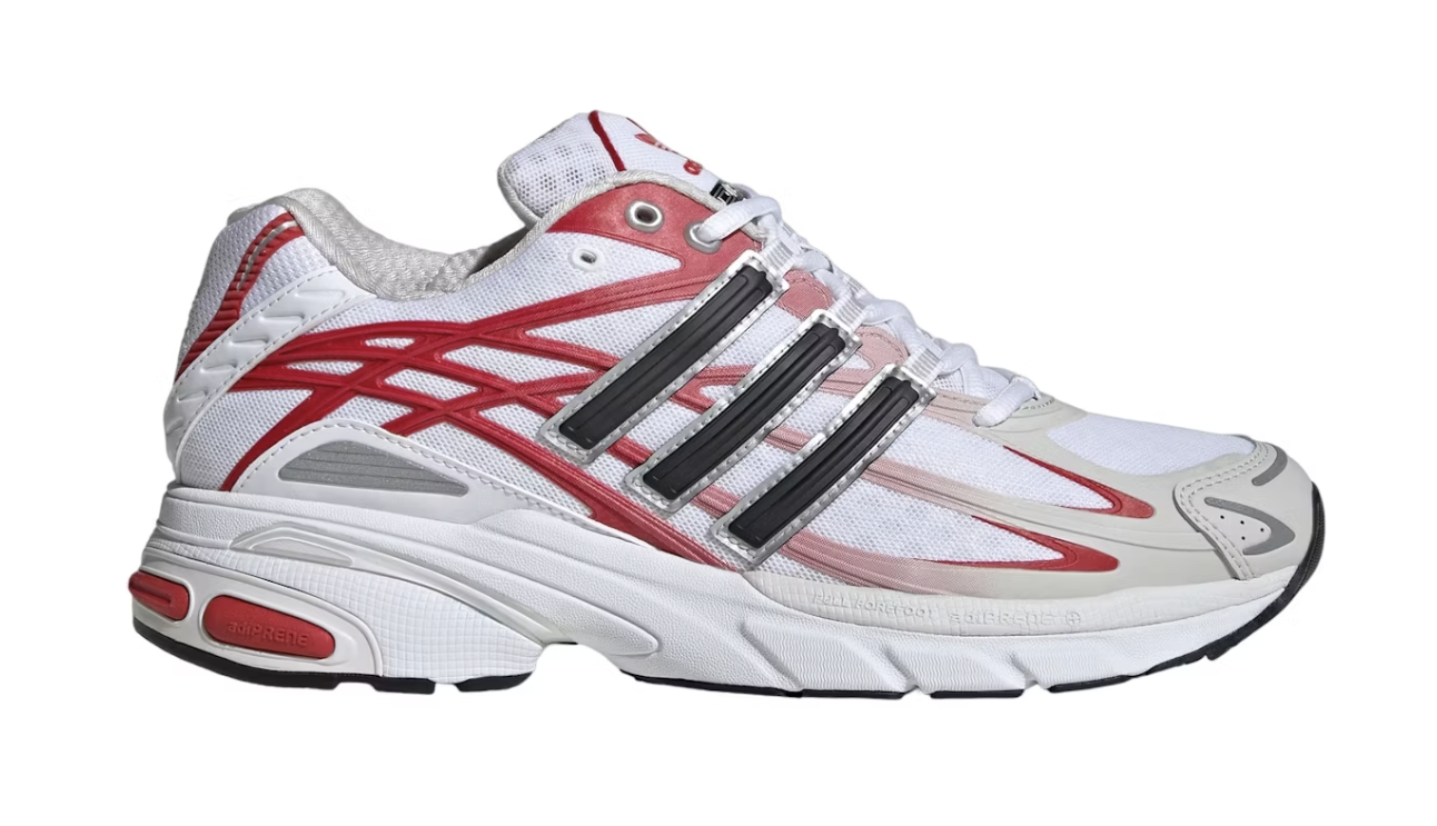 A stylish sneaker with a mix of white, black, and red patterns, featuring a detailed sole and sleek design intended for sports and casual wear
