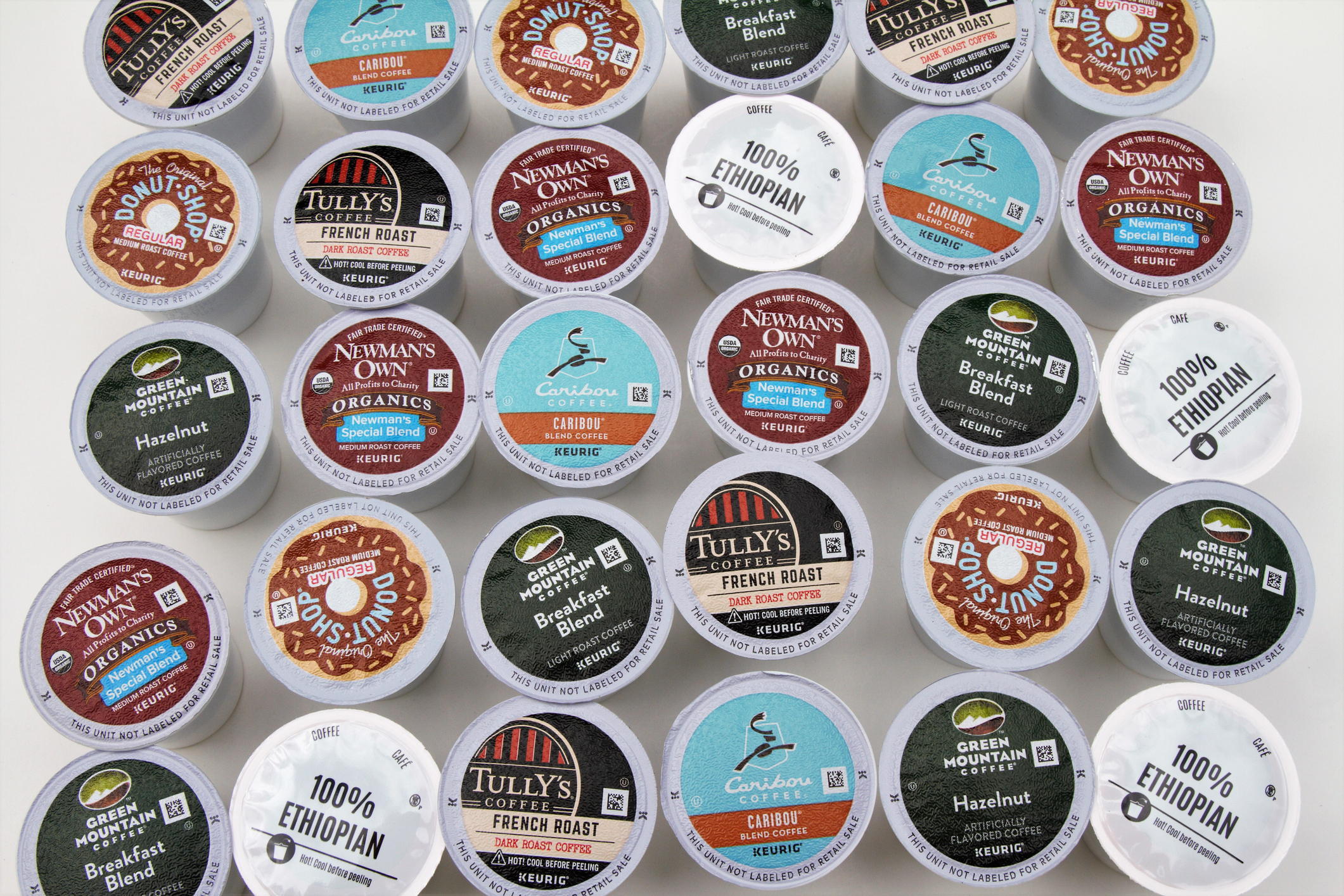 Variety of K-Cup coffee pods from brands including Tully's, Newman's Own, and Caribou Coffee. Flavors include French Roast, Ethiopian, and Hazelnut