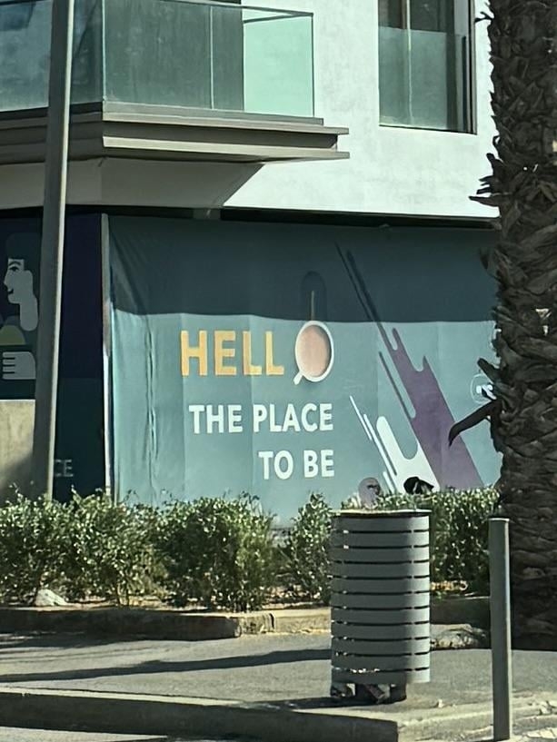 Text on a building reads &quot;Hell the place to be,&quot; it intends to say &quot;Hello&quot; but they've used a coffee mug as the O and it really doesn't appear to be part of the actual text at all