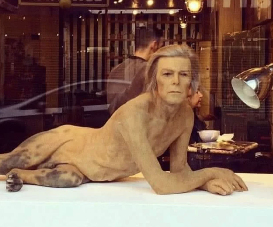 David Bowie nude sculpture/window display in a coffee shop, resembling the character from the movie "The Man Who Fell to Earth."