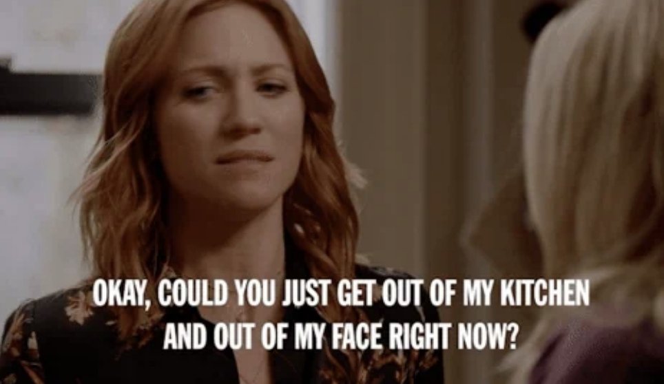 A woman with red hair is speaking to someone offscreen. The overlaid text reads, &quot;OKAY, COULD YOU JUST GET OUT OF MY KITCHEN AND OUT OF MY FACE RIGHT NOW?&quot;