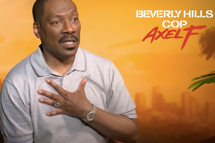 Eddie Murphy, in a short-sleeve polo, gesturing with one hand during an interview for "Beverly Hills Cop: Axel F."