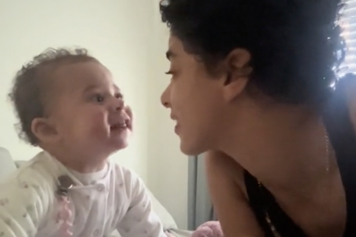 赤ちゃんと大人がベッドで向き合い笑顔で会話している様子。テキストには「I love our conversations」の文字。