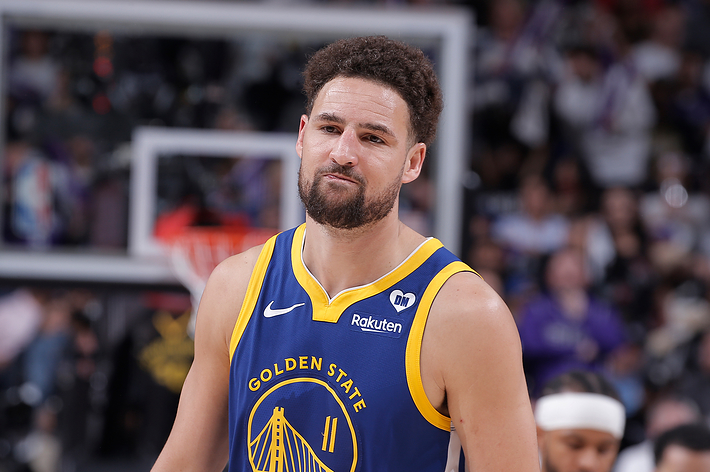 Klay Thompson of the Golden State Warriors in a basketball arena, wearing his team jersey