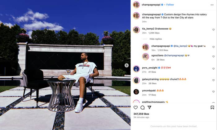 Drake sitting at an outdoor table, wearing a white outfit with sneakers, looking sideways. Instagram post by champagnepapi