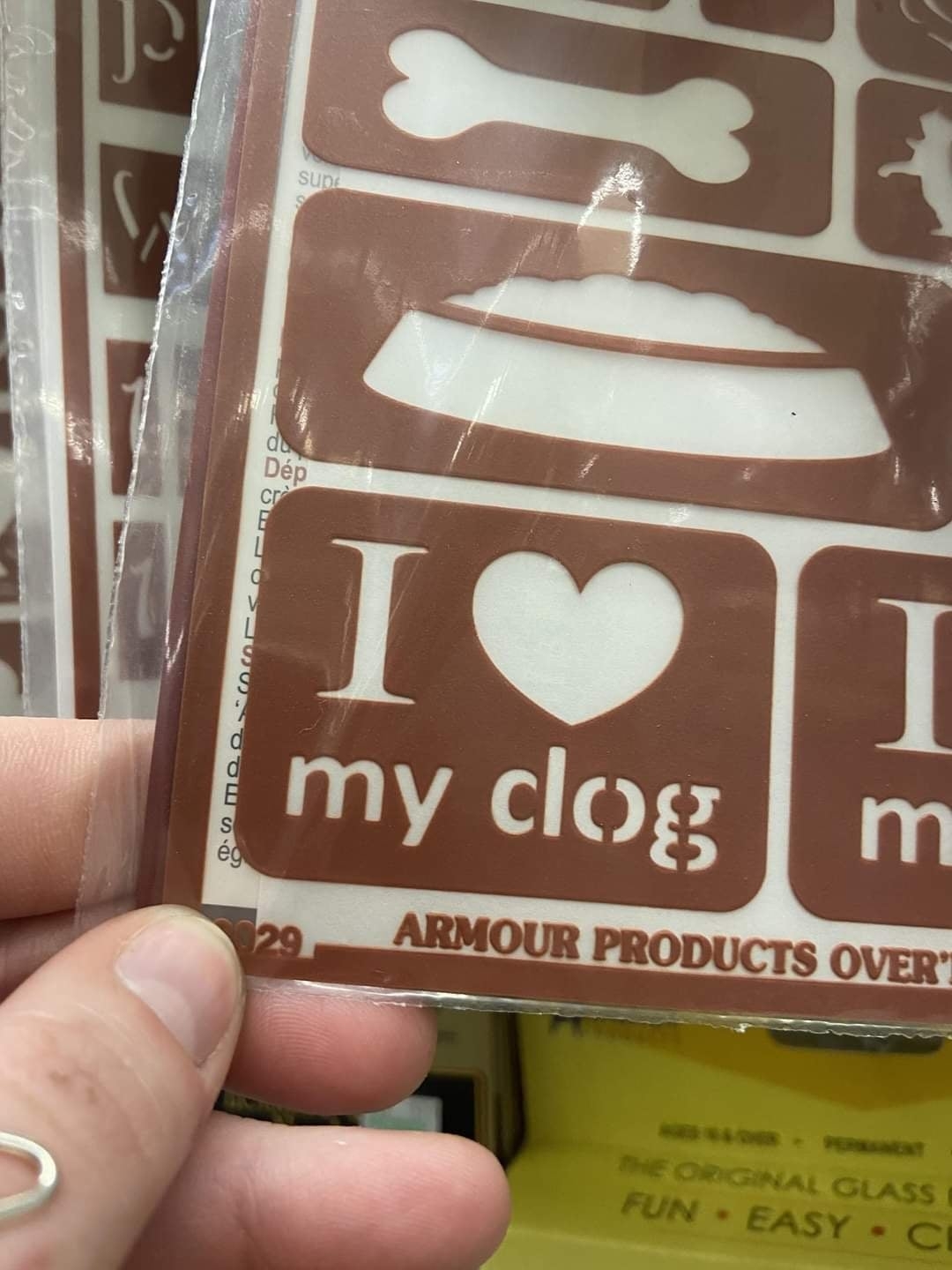 A person holding a stencil with the text &quot;I ♥ my clog;&quot; it's supposed to read &quot;I ♥ my dog,&quot; but there's a space in the d