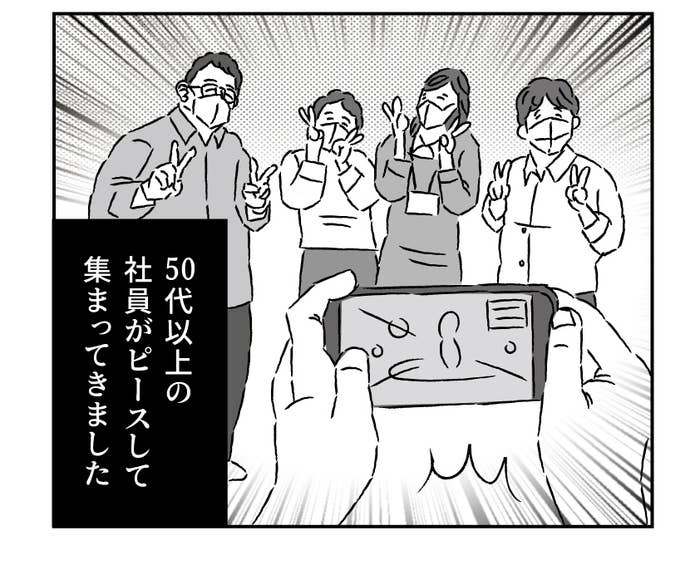 ピースしながらゲームをする玖島川さんの前に集まった社員たち