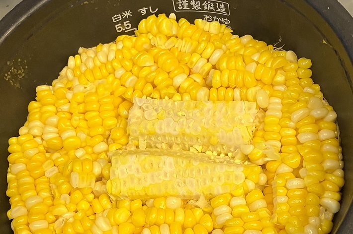 炊飯器の中に、美味しそうに茹で上がったトウモロコシの実と芯が入っている。