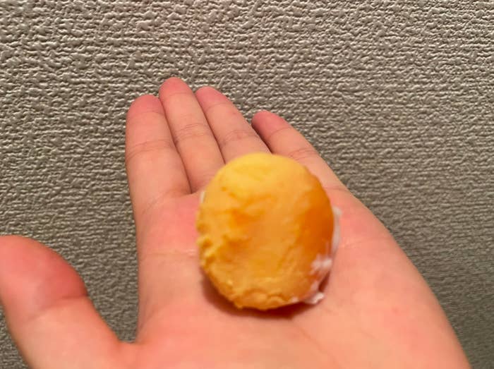 手のひらに乗った小さなオレンジ色のボール。