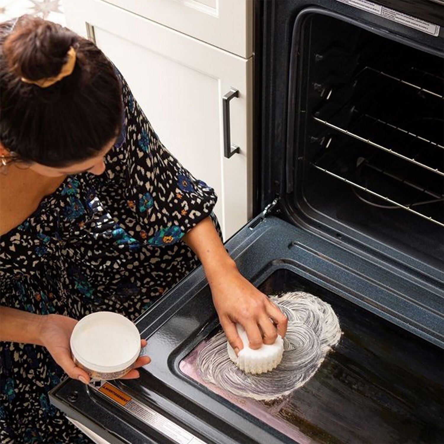 Seseorang membersihkan bagian dalam oven dengan kit