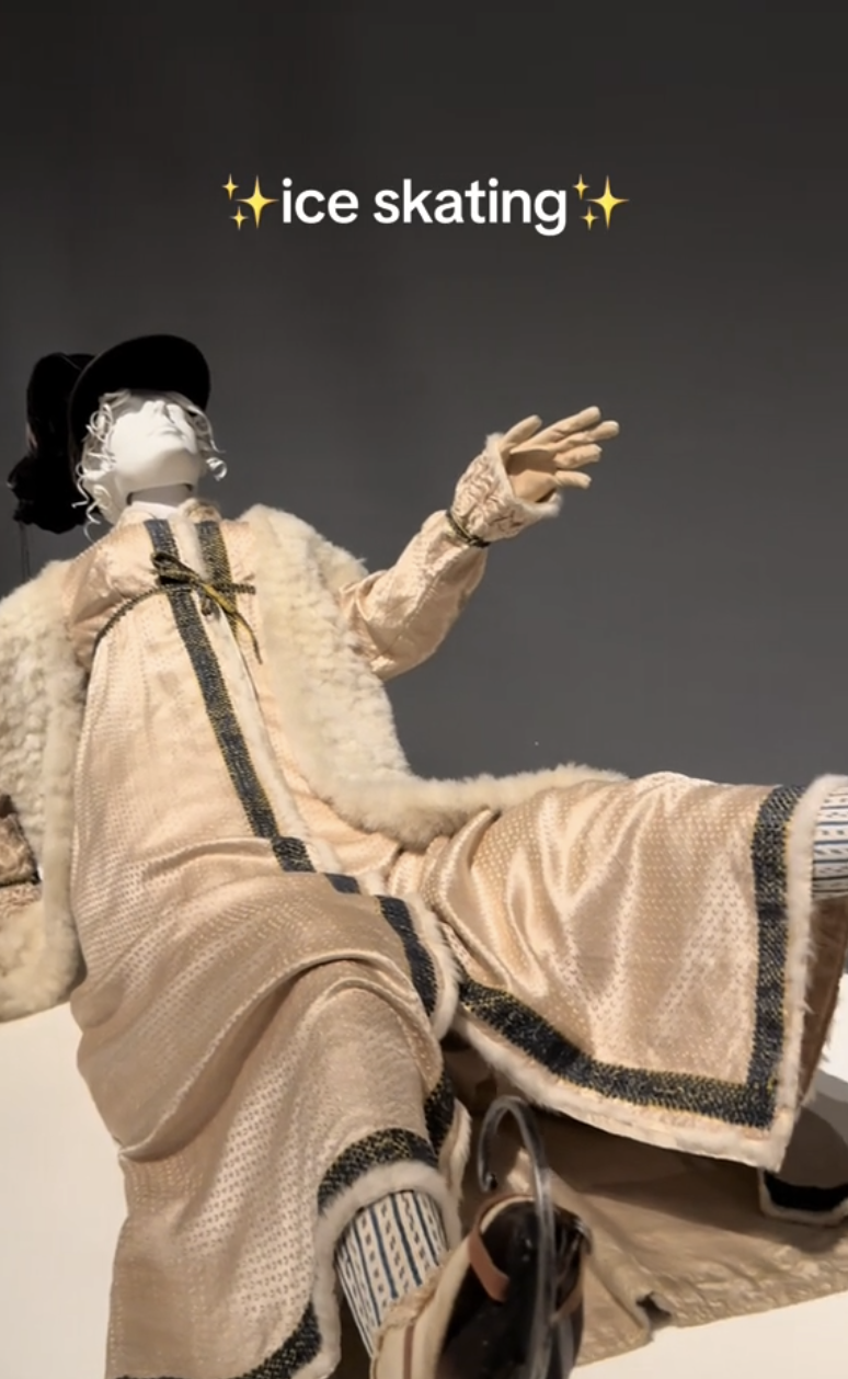 A mannequin dressed in vintage-inspired ice skating attire, including a long coat, gloves, hat, and boots. Text reads &quot;✨ice skating✨&quot;