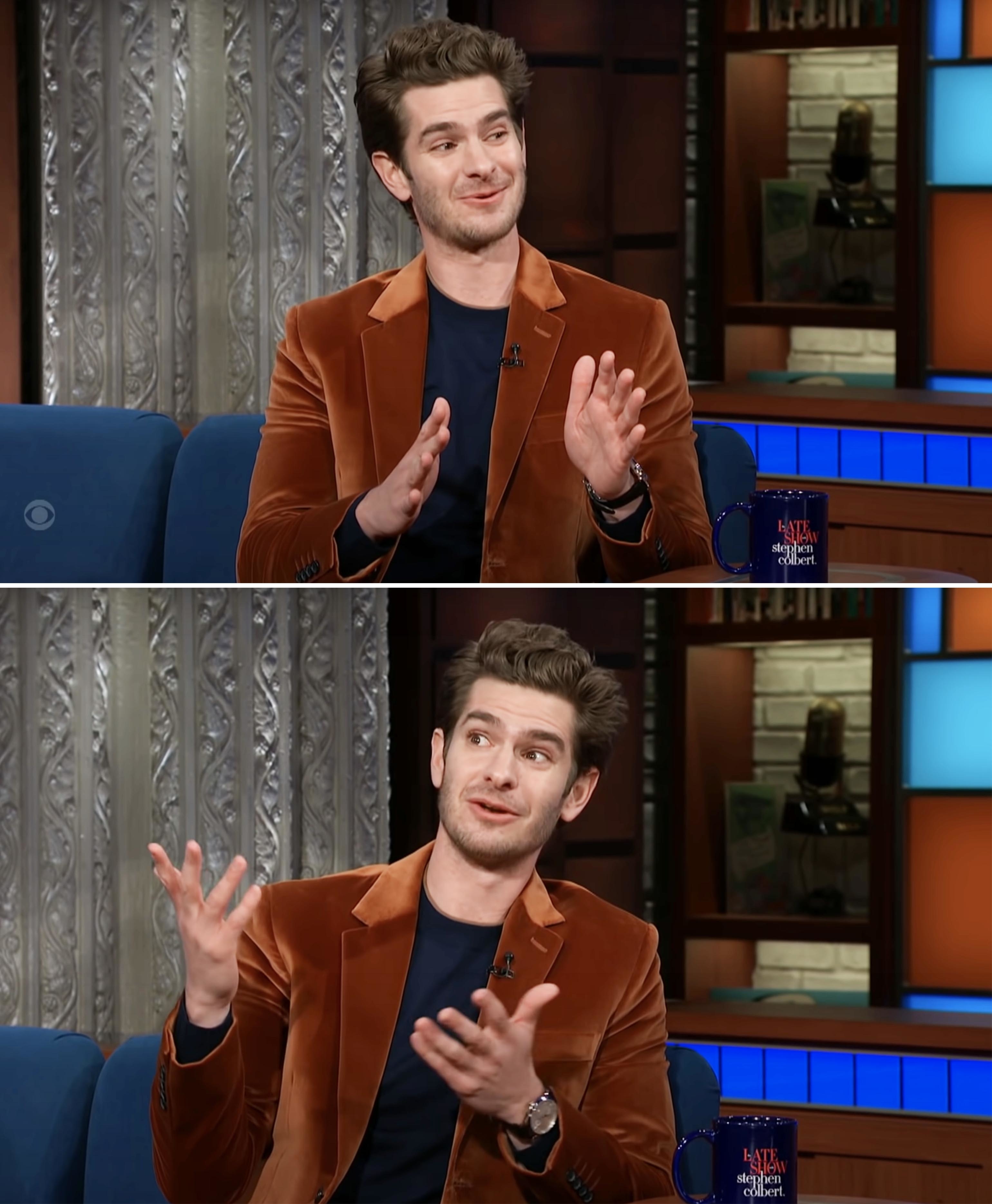 Andrew Garfield in a brown velvet blazer, talking and gesturing during an interview on The Late Show with Stephen Colbert