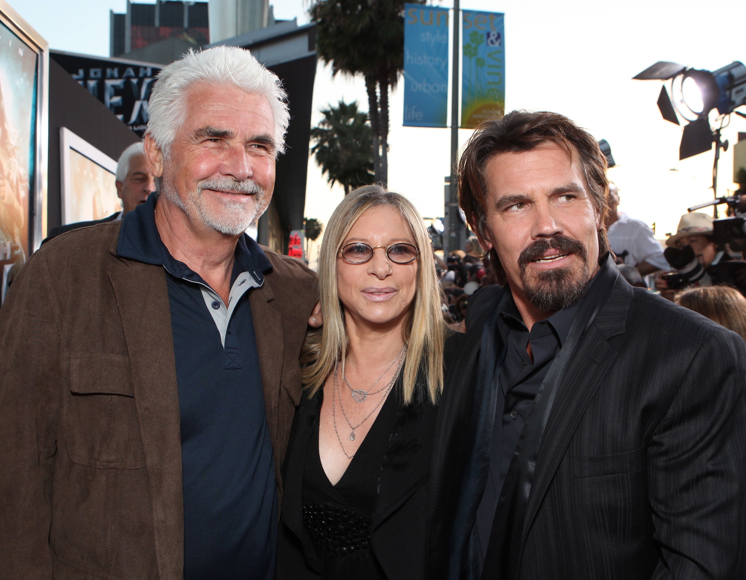 James Brolin, Barbra Streisand, and Josh Brolin pose together at a movie premiere event. All are dressed in stylish, dark-colored attire