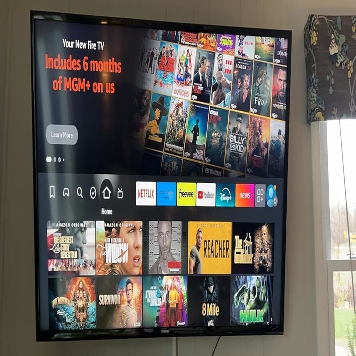 A TV screen displaying a Fire TV interface with promotional text offering six months of MGM+ included. Various movie and TV show options are shown on the screen