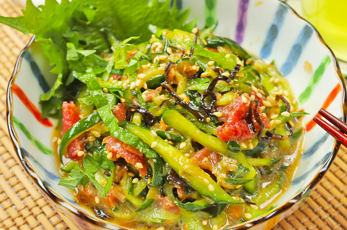 カラフルな器に盛られた韓国風の料理。野菜と海藻がゴマと共に混ぜられている。