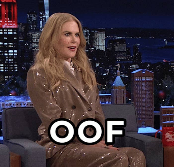 Nicole Kidman on a talk show wearing a sequin suit, reacting humorously with the word "OOF" displayed on the screen