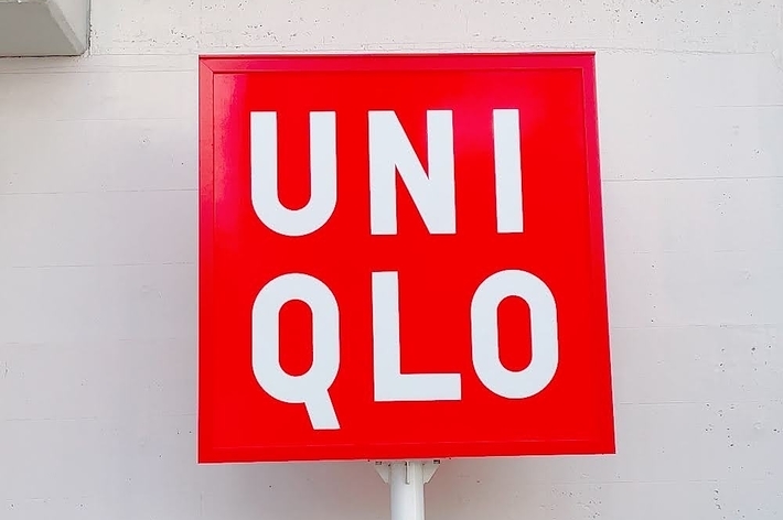 ユニクロの赤い看板に「UNIQLO」と大きな白い文字が書かれています。