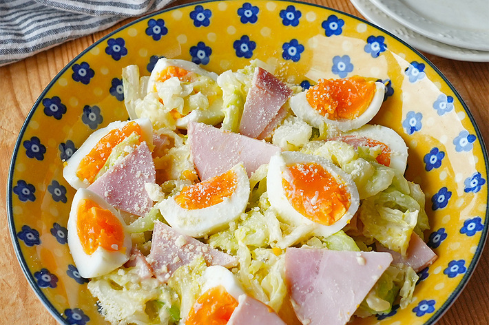 卵、ハム、キャベツが盛り付けられた料理。