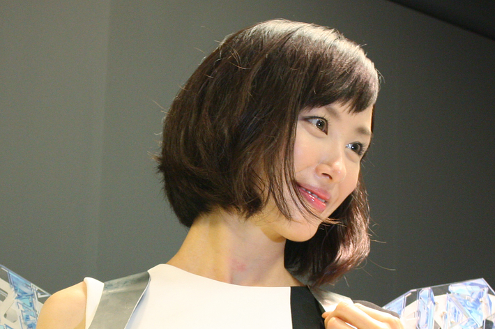 女性が近未来的な肩飾りをつけてポーズをとっています。