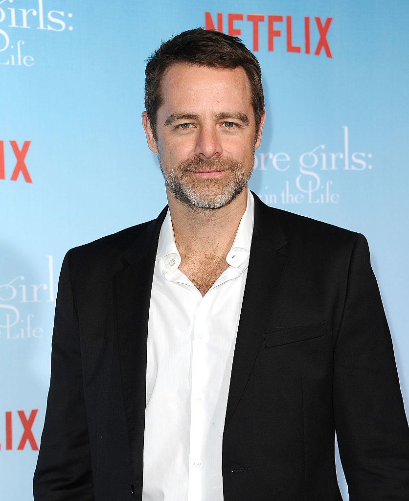 David Sutcliffe in a suit poses at a Netflix event for "Gilmore Girls: A Year in the Life"