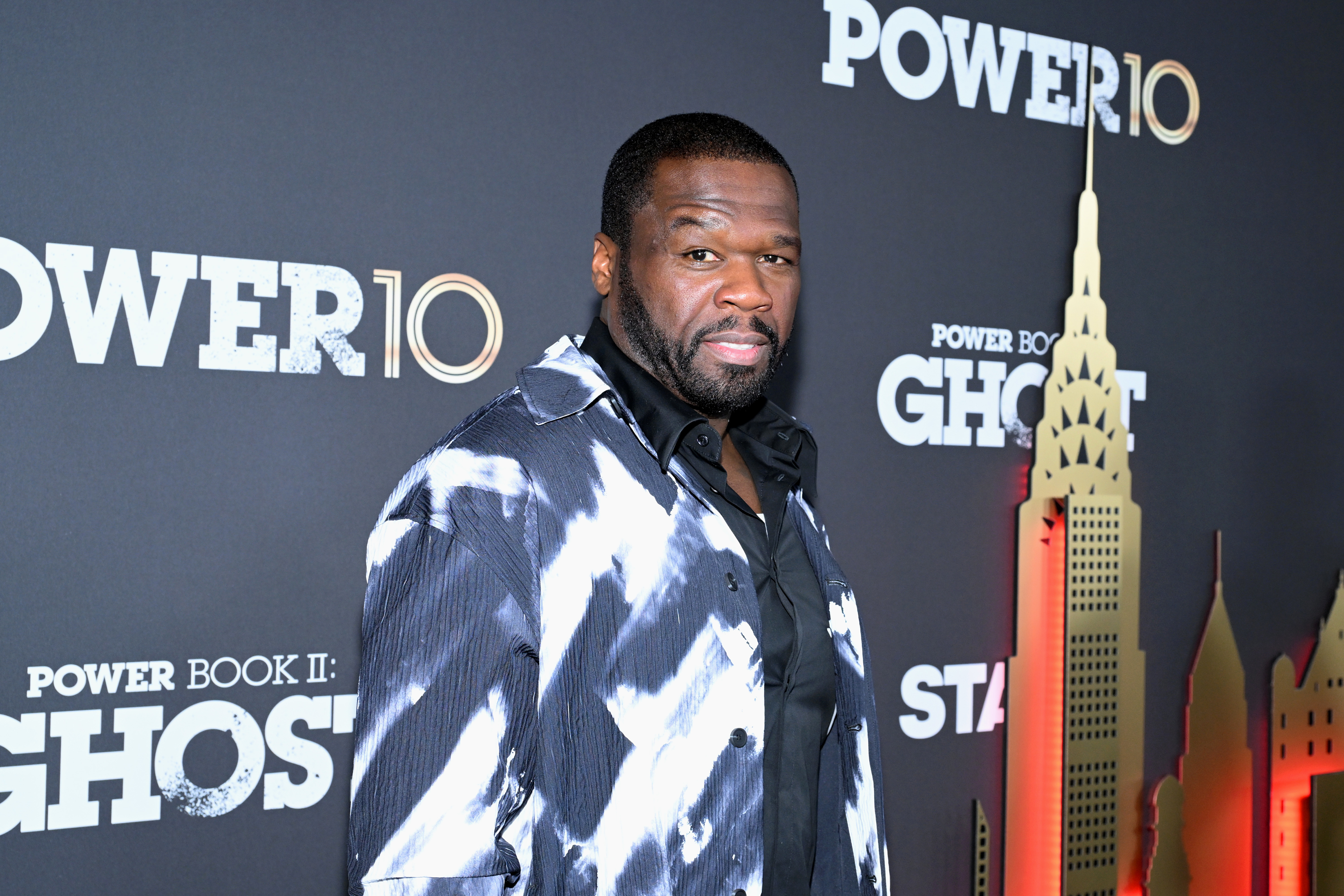 50 Cent on the red carpet at the "Power Book II: Ghost" premiere wearing a patterned jacket over a black shirt