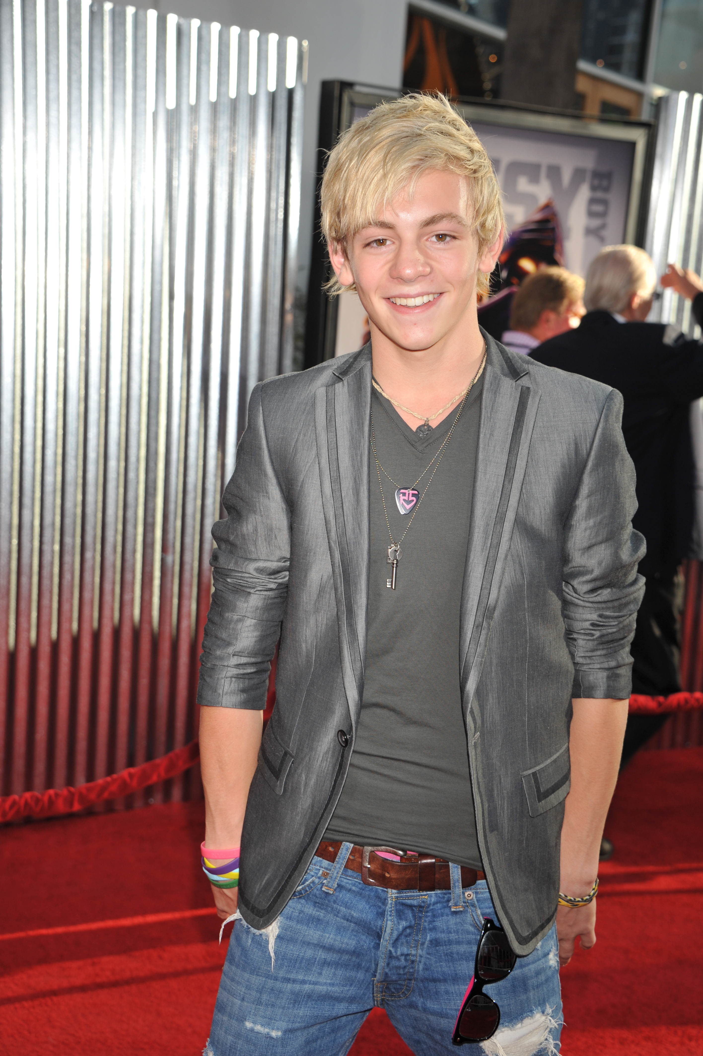 Ross Lynch on the red carpet wearing a blazer over a t-shirt and distressed jeans at a celebrity event