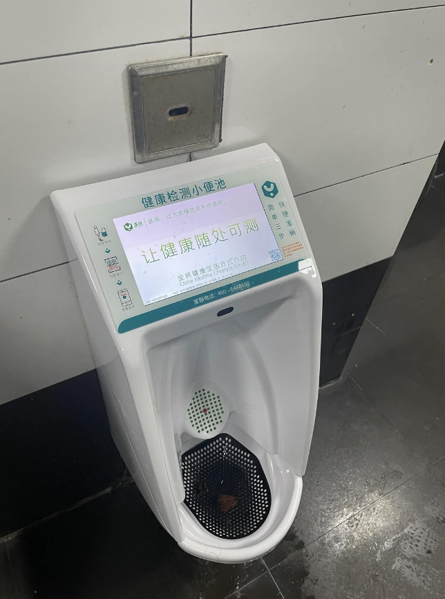 Urinal with a health testing screen above it, displaying Chinese text and health information