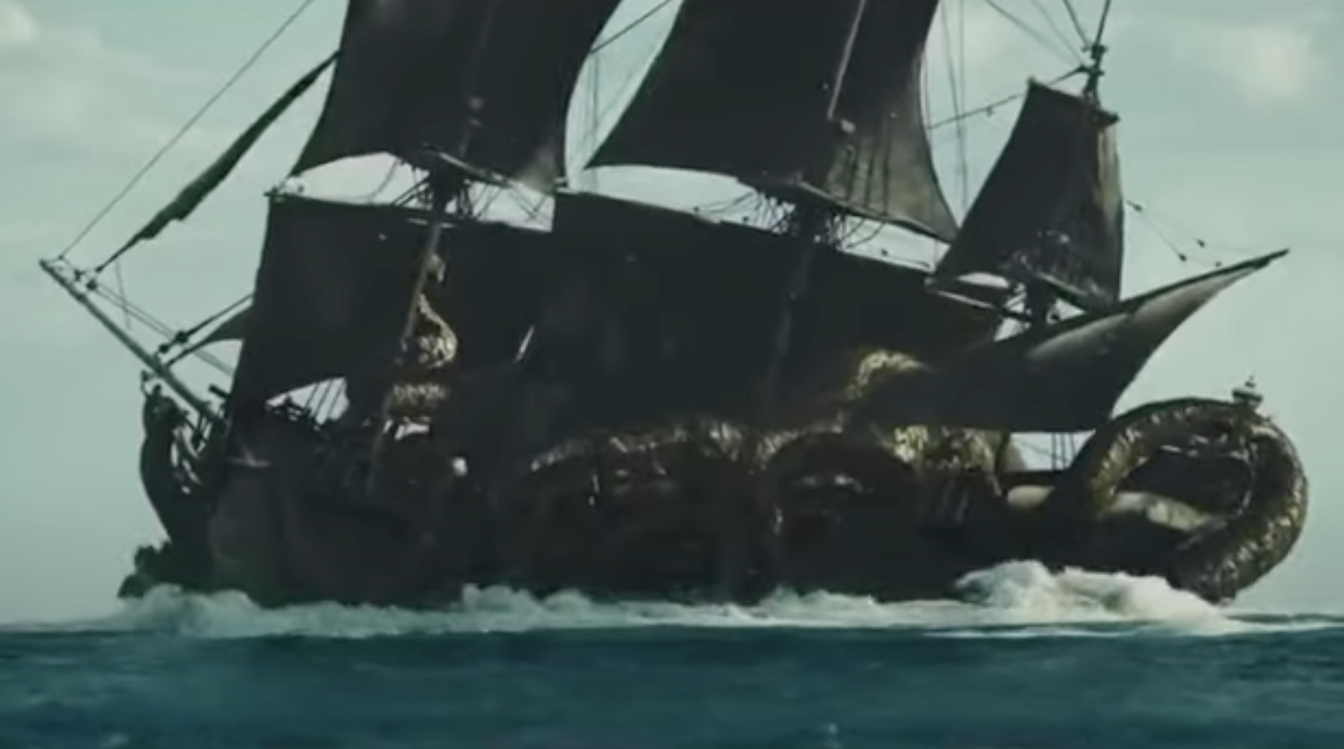 A large pirate ship in rough seas is entangled by a giant sea monster with long, coiling tentacles